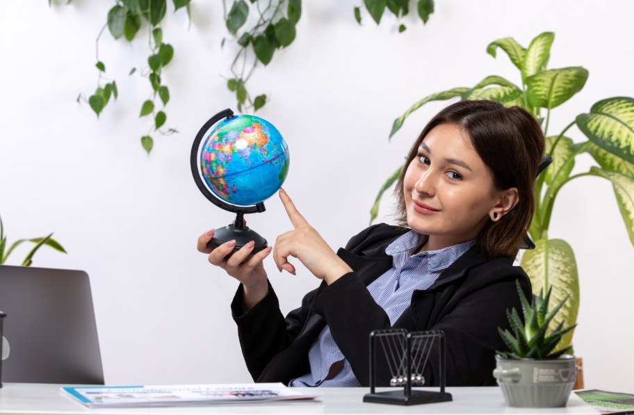 A professional pointing to a globe, representing our global client reach